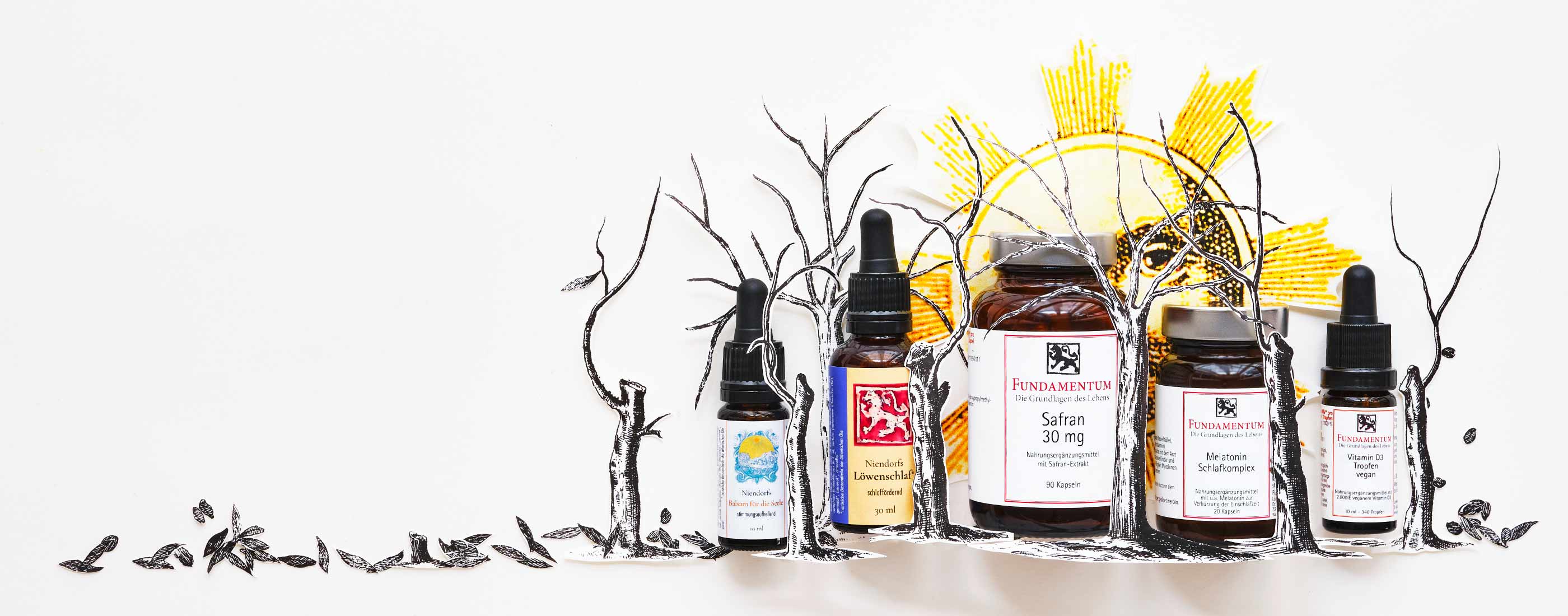 Sechs Fläschchen aus der Kategorie Öle für die Psyche mit botanischen Zeichnungen und Kräuterzutaten, arrangiert auf weißem Stoff