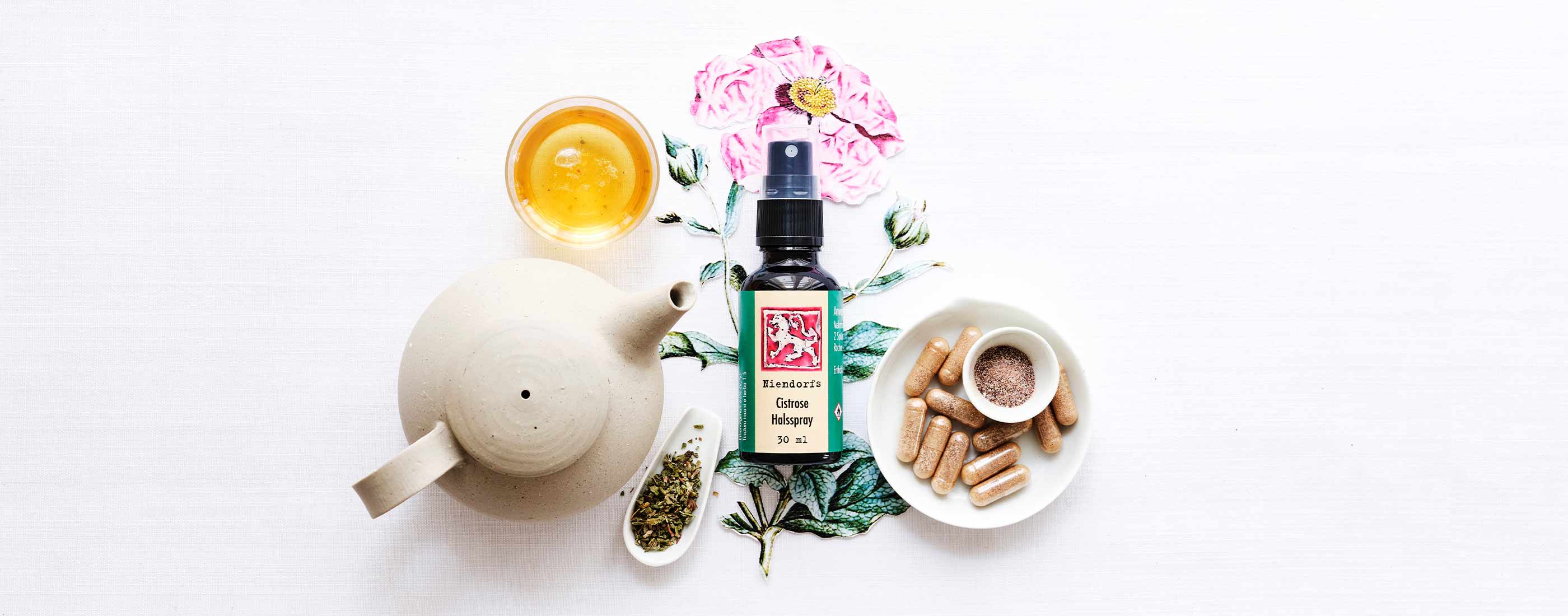 Niendorfs Cistrose Halsspray (30 ml) arrangiert mit Tee, Kräutern und Kapseln zur natürlichen Unterstützung der Abwehrkräfte – auf weißem Tuch mit botanischer Illustration